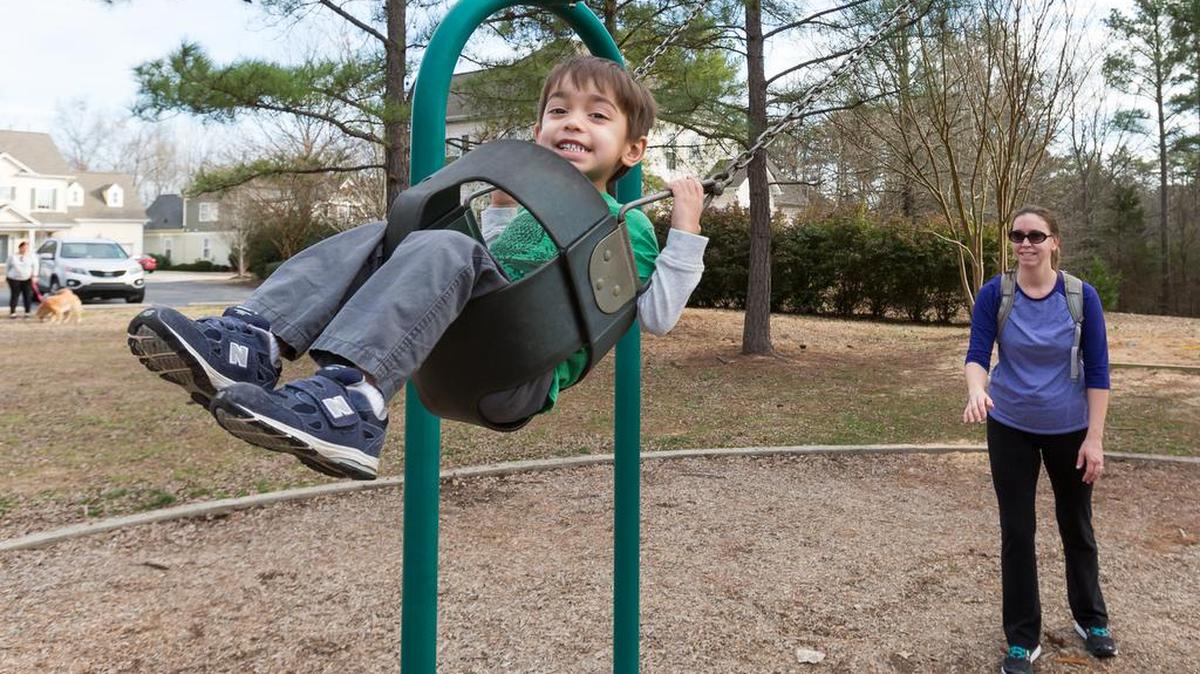 Jenson Vallyathan enjoys the warm weather on the swing with his mom at Trail Head Park in Tega Cay in this January file photo.