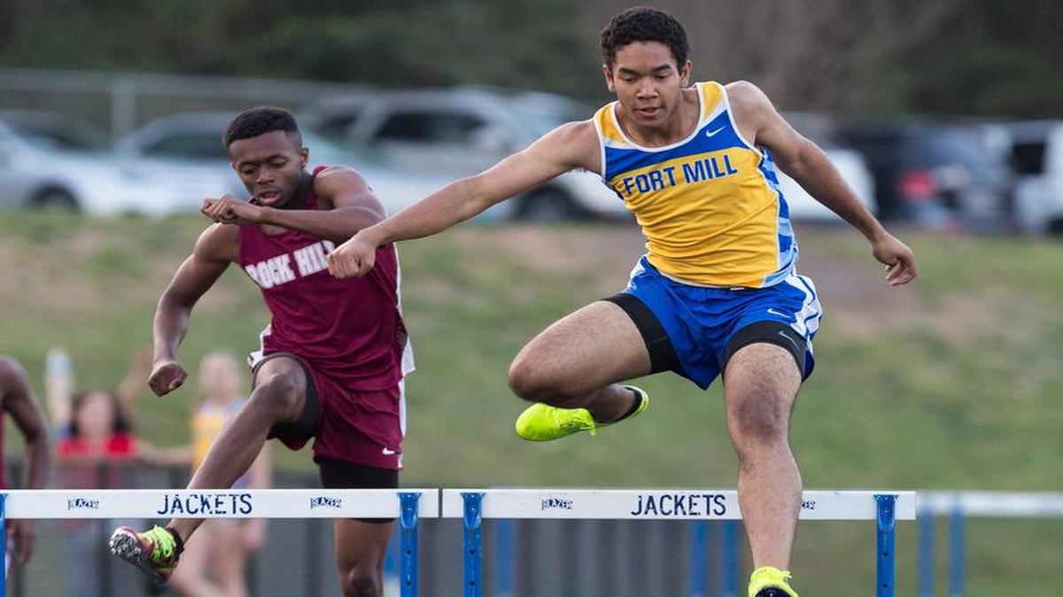 The Yellow Jackets’ Dominic Williams, right, clears a hurdle on his way to first place in the 400 hurdles at the March 23 meet at Fort Mill.