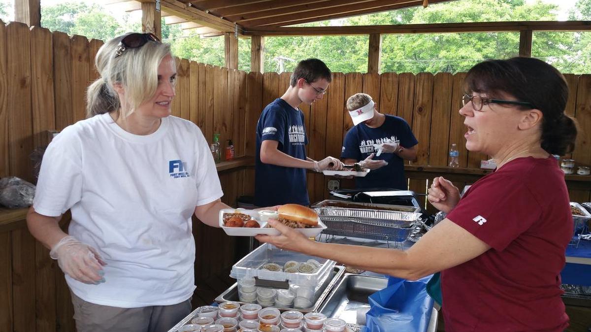 
Denise Hahn serves a plate of BBQ at the FMHS "March to Normandy" fundraiser held at the Fort Mill VFW Post.
