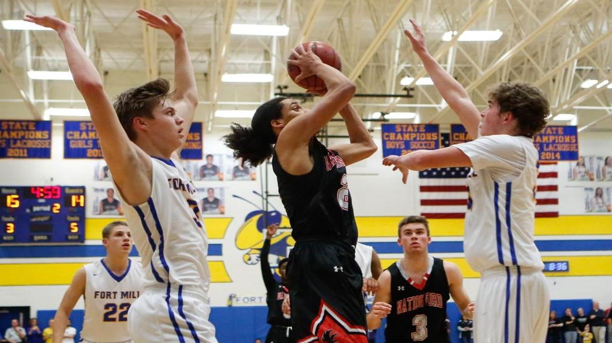 Nation Ford's Cameron Holmes tries to work around close Fort Mill defenders in a key showdown won by the Yellow Jackets Friday.