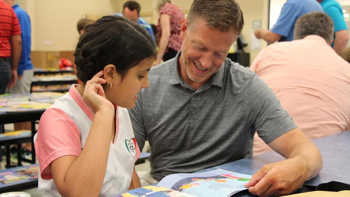 Karl Runge, Fort Mill Rotary Club member, reads with a summer Lunch and Learn program member. A club grant provided 15 books to each student in the program.