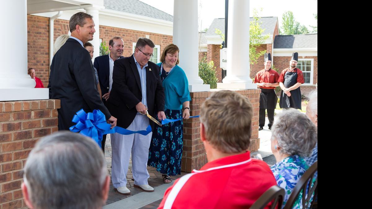 Local officials, from left, York County Regional Chamber President Rob Youngblood, Tega Cay Mayor George Sheppard and the Rev. Joanne Sizoo of Grace Presbyterian Church cut the ribbon as Wellmore of Tega Cay holds a grand preview event Thursday.
