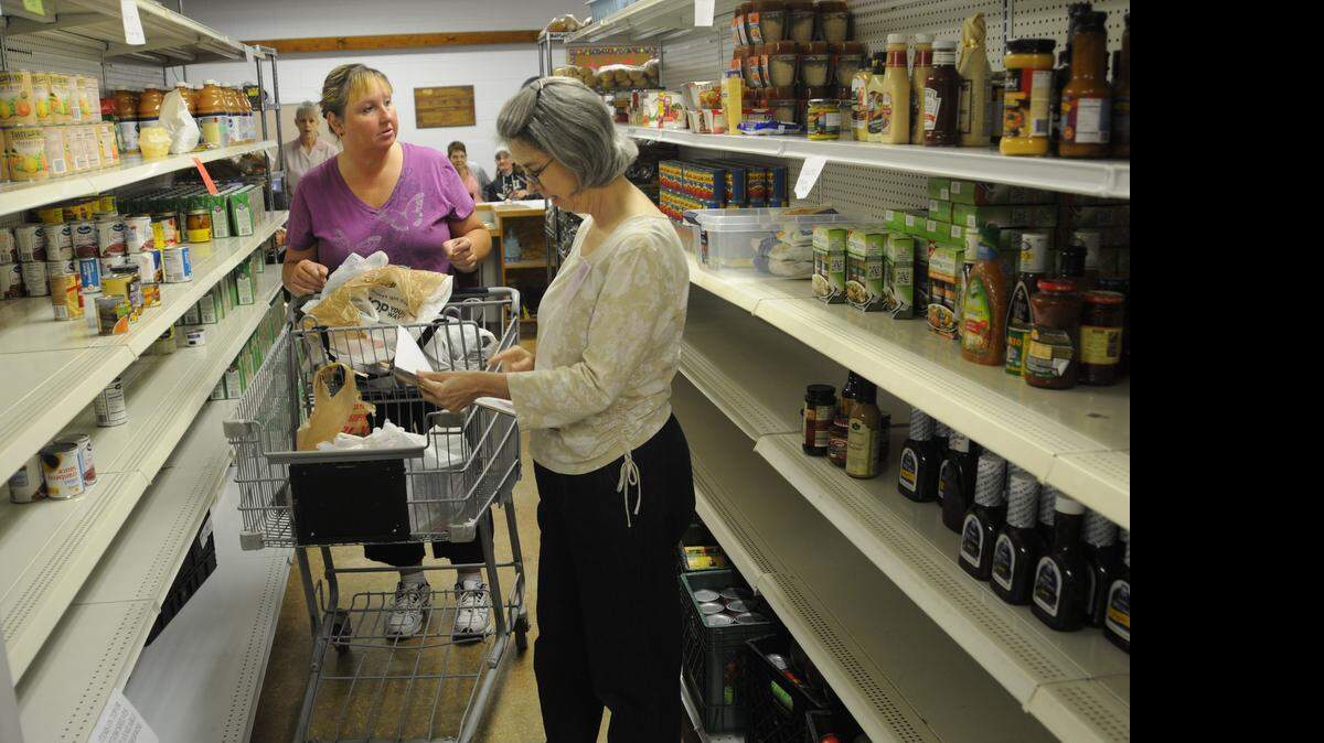 
Client Cathy Cook and volunteer Julie Young peruse the pantry setup at Clover Area Assistance Center. The agency has cut its ties with Second Harvest Food Bank of Metrolina.
