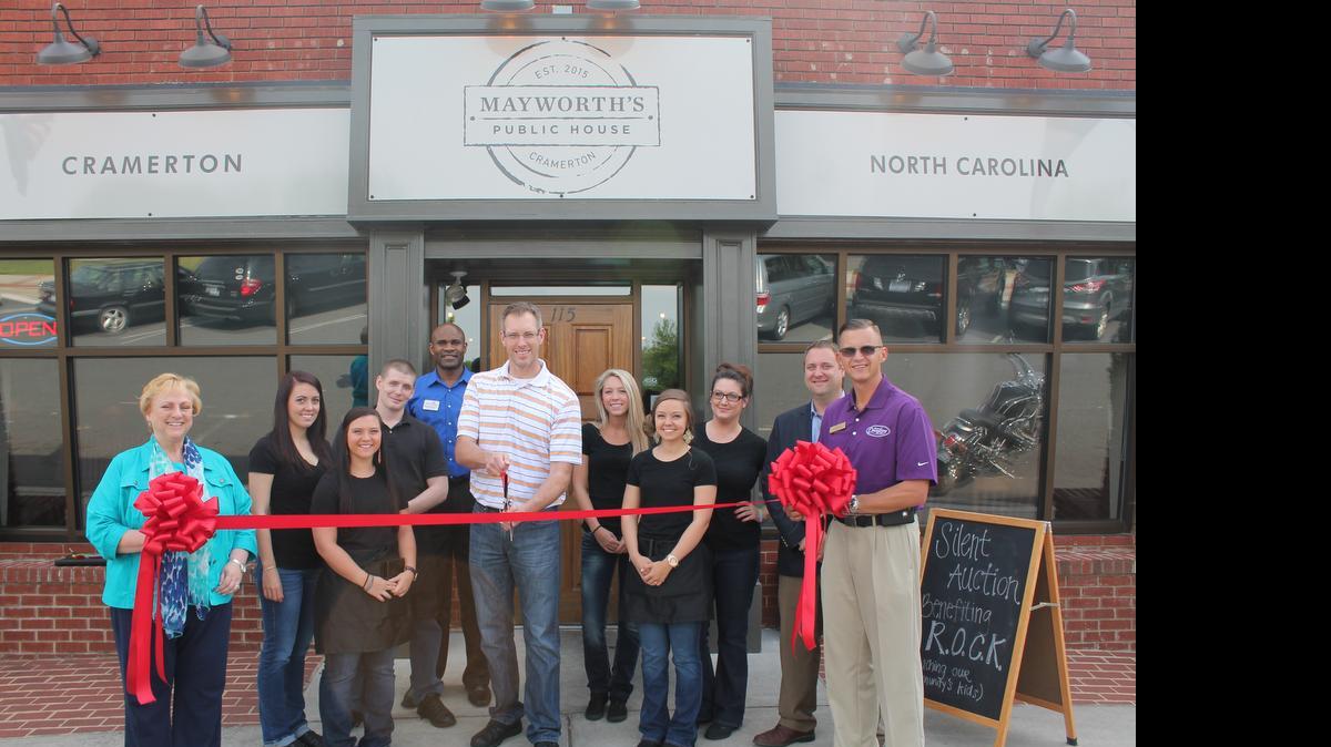 
Chuck Craig, operating partner of Mayworth’s Public House in Cramerton, cuts the ribbon for the new restaurant with Montcross Area Chamber of Commerce members. Holding the ribbon are Cramerton Mayor Ronnie Worley and Chamber Board chairwoman Melia Lyerly of Lyerly Agency. 
