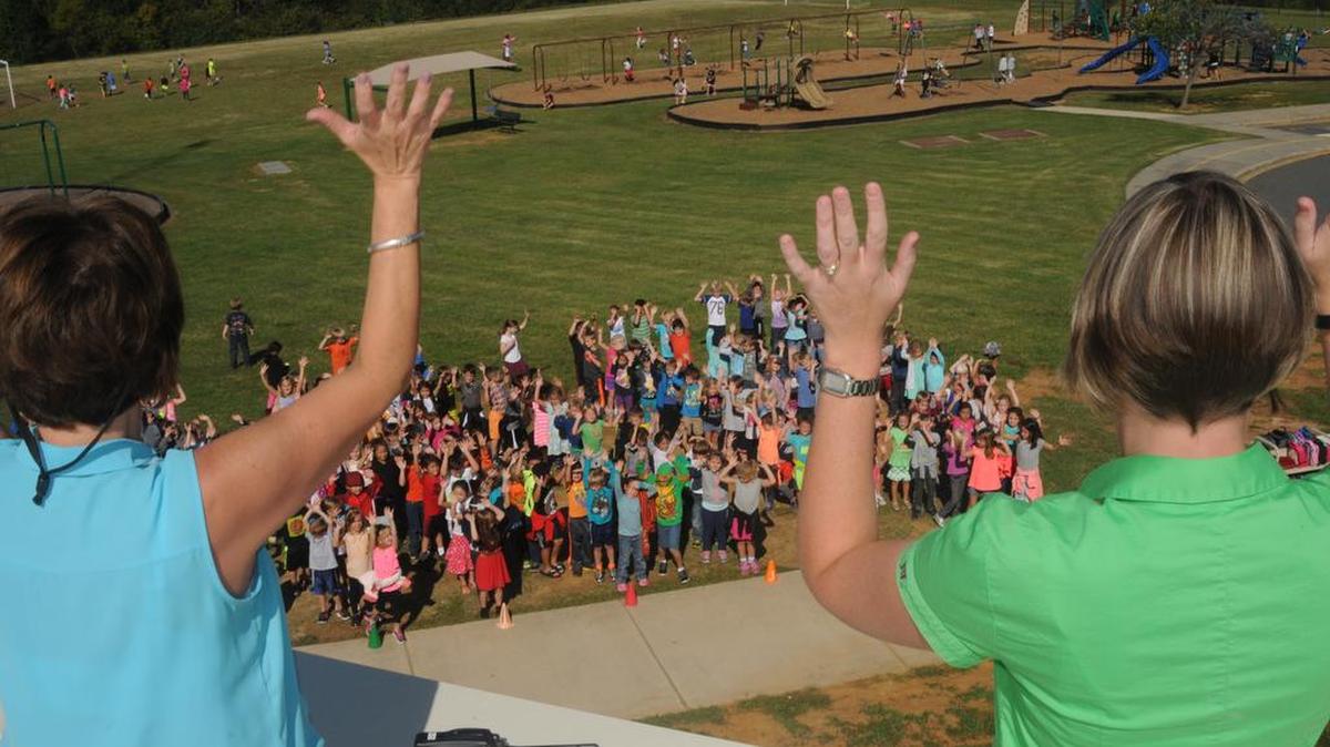 
Principals Georgia Westmoreland, left, and Lori Maczko entertain students Oct. 8 at Crowders Creek Elementary School. The administrators agreed to work from the roof of the school if students met a fundraising challenge.
