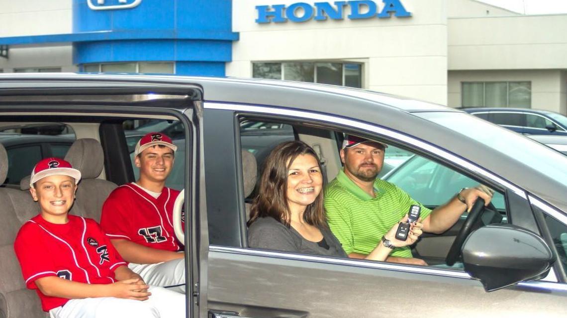 Jason Hurley and Stephanie Hurley in the front of the new minivan they won after buying a raffle ticket from brothers Seth and Caleb Hanson.