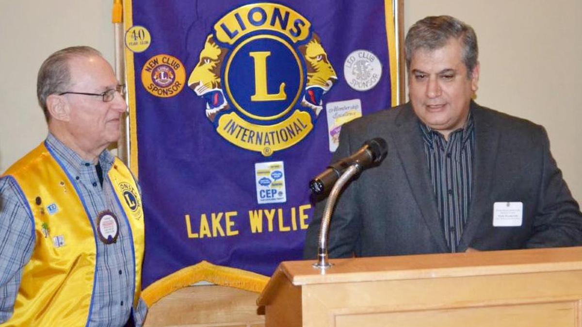Yem Huseyin, right, owner of Lake Wylie Pizza & Italian Restaurant, is honored by River Hills/Lake Wylie Lions Club president Len Fleet at River Hills Country Club.