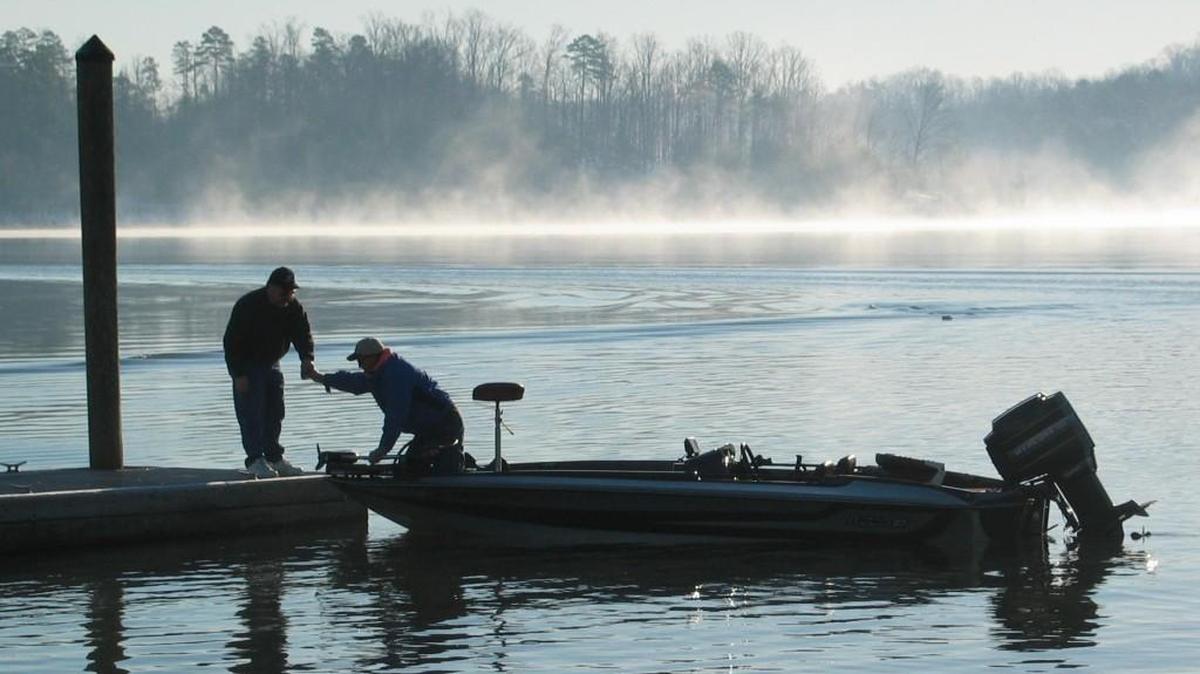 Fog shrounds the snowy shoreline of Lake Wylie as two anglers ready their boat for a day of largemouth bass fishing. Several large fishing tournaments are planned in March.
