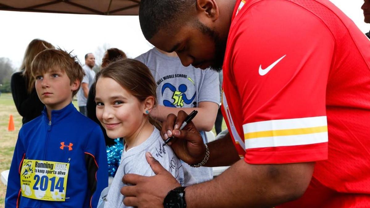 Fort Mill graduate Vance Walker signs his autograph on Hannah Maslowski's shirt when the Fort Mill Middle School Booster Club hosted a 5K race and fun run at Walter Elisha Park in Fort Mill in 2014. Walker has been named to the York County Sports Hall of Fame