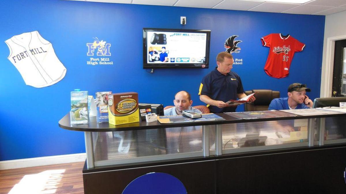 
Brothers Chris James, left, and Steven Biggs, right, answer calls at Fort Mill Auto Service & Fleet on U.S. 21 in Fort Mill. Owner Kevin Gibson, center, plans to use his business to help support local high school athletic teams.
