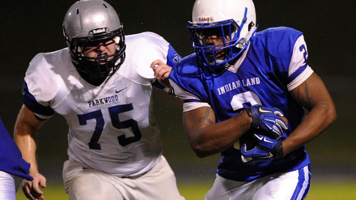 Lee Massey (2) of Indian Land covers the ball as he runs to the outside with a Parkwood defender in pursuit.