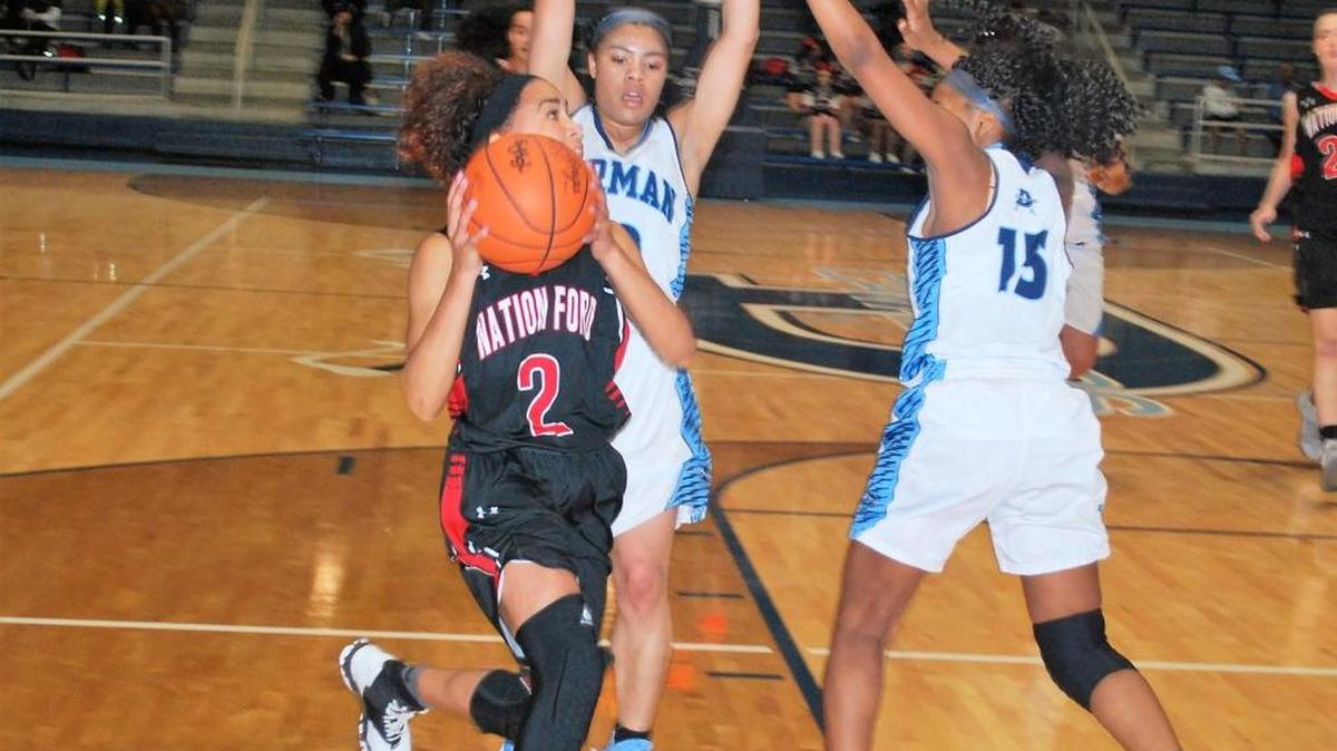Nation Ford’s Ellona Moulds looks to shoot around two defenders in the Falcons game against Dorman.