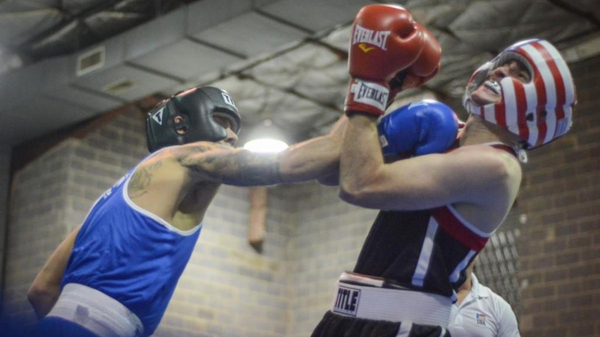 Christoper Corrado, left, lands a blow to opponent William Sweet during Light Bright Boxing Fight Night at the Comenius School in Fort Mill in 2014.