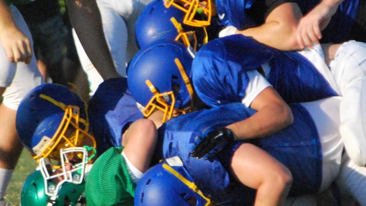 Fort Mill’s defense gang tackles a player from Weddington during a scrimmage last week.