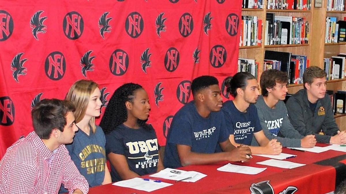 From left, Kirk Rygol, Madison Gleason, Jori Benton, Michael Smith, Will Martin, Blake Baker and Brad Young, all sign national letters of intent to play college athletics after graduating this spring from Nation Ford High.