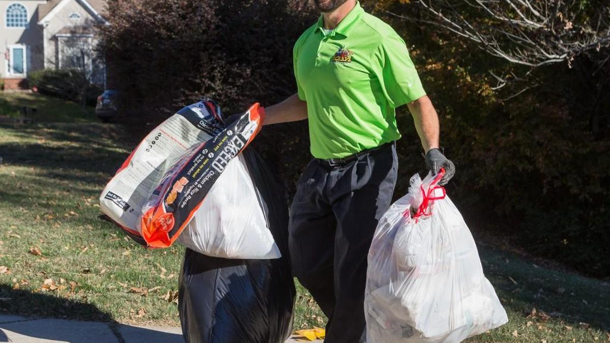 Scott Bolin of Scraps carries trash from the house on a stop in Regent Park.