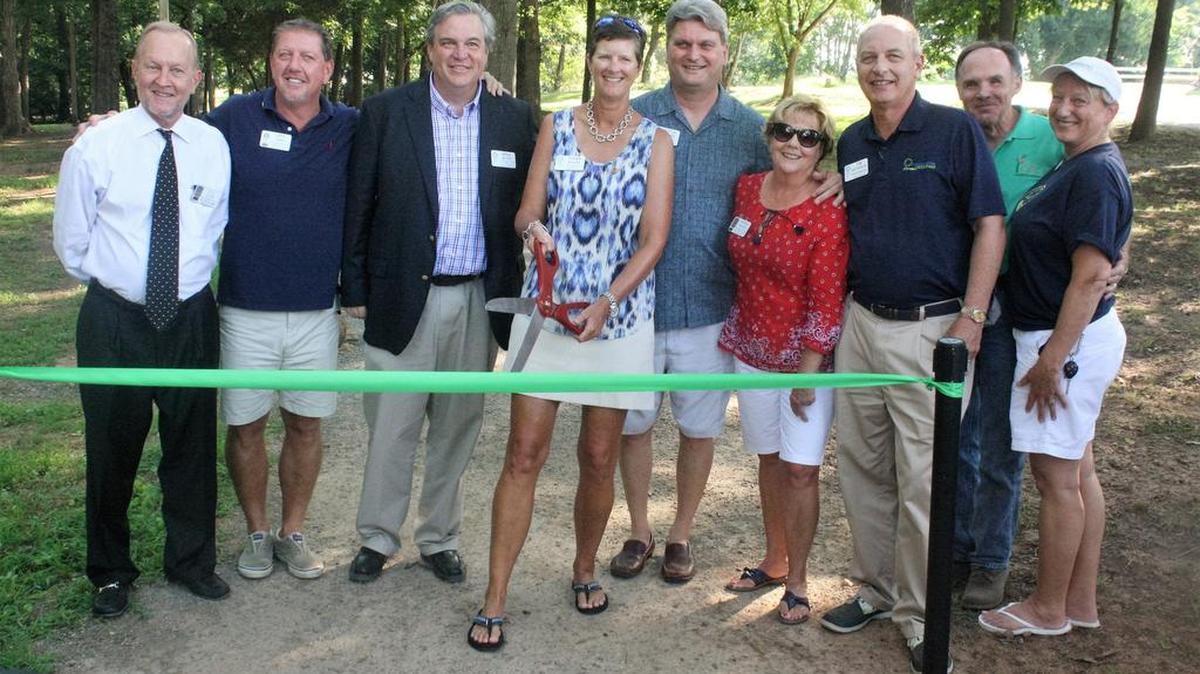 Fort Mill Rotary Club member Susan Fuller cuts the ribbon to officially open Rotary Way at the Anne Springs Close Greenway on June 31.