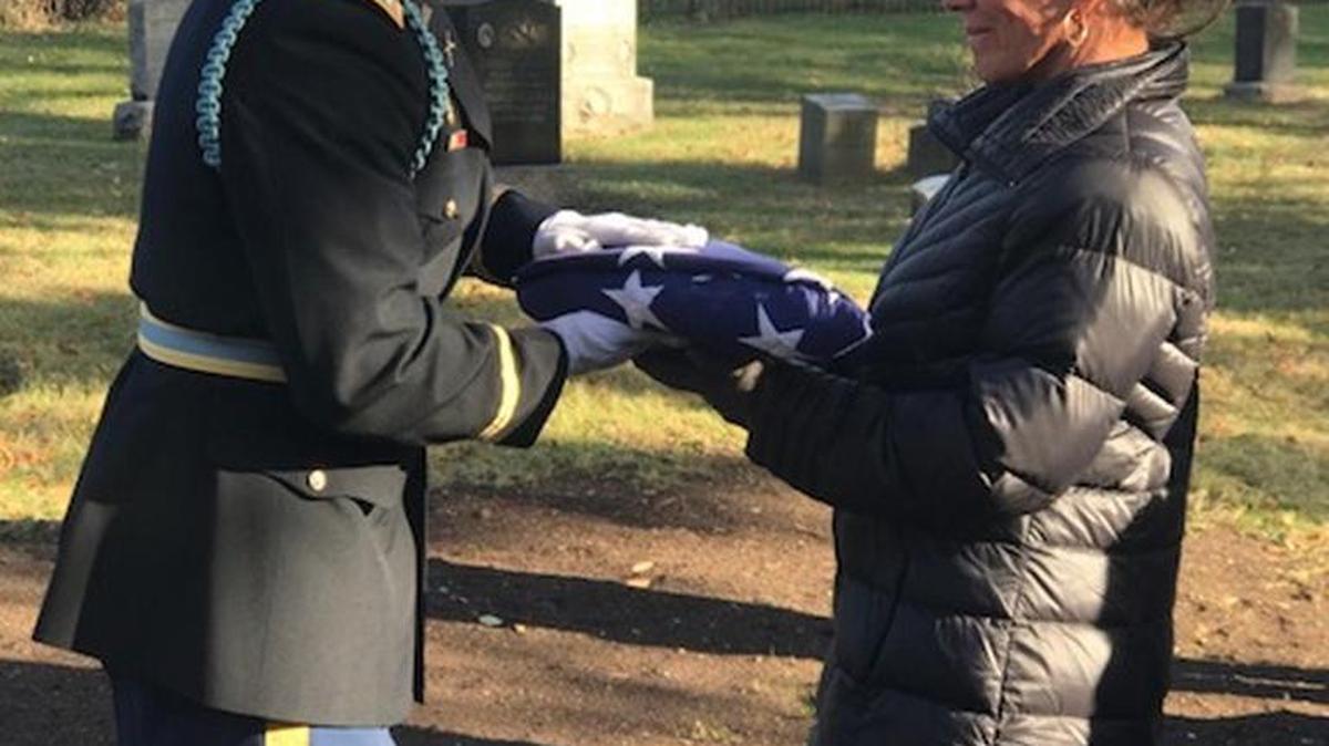 Fort Mill resident Maureen Clary receives a U.S. flag from a National Guardsman at a dedication ceremony for her great-great-grandfather, Charles McMurtrie, in Paterson, N.J.