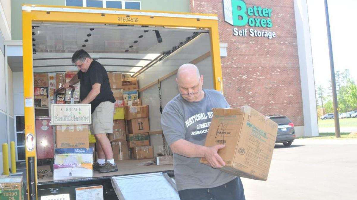 Joey Savino, who recently moved to the area from Durham, N.C., unpacks boxes at Better Boxes Self Storage with help from Frank Signoretto.