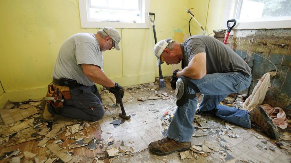 Ken Hargett, left, and Tim Hallman work to remove old floor covering from the kitchen in a house on Avery Street in September. The entire kitchen is being repaired as part of a Habitat for Humanity of York County project in Paradise. The workers are members of the Comporium Pioneer Club. Another round of repair projects for homes in the neighborhood has been announced.
