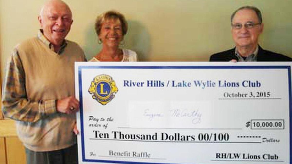 
Gene McCarthy, left, with wife Lisa receive a $10,000 check from River Hills/Lake Wylie Lions Club President Len Fleet.
