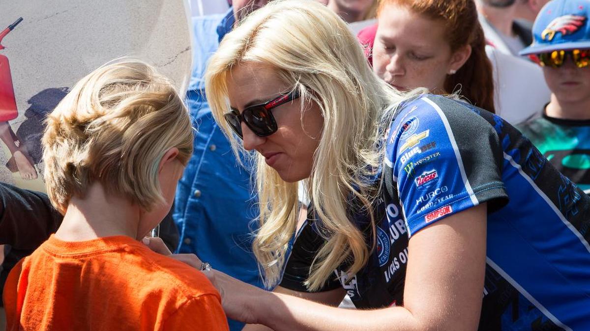 Courtney Force signs a fan's T-shirt during the Four-Wide Nationals at zMax Dragway in 2016.