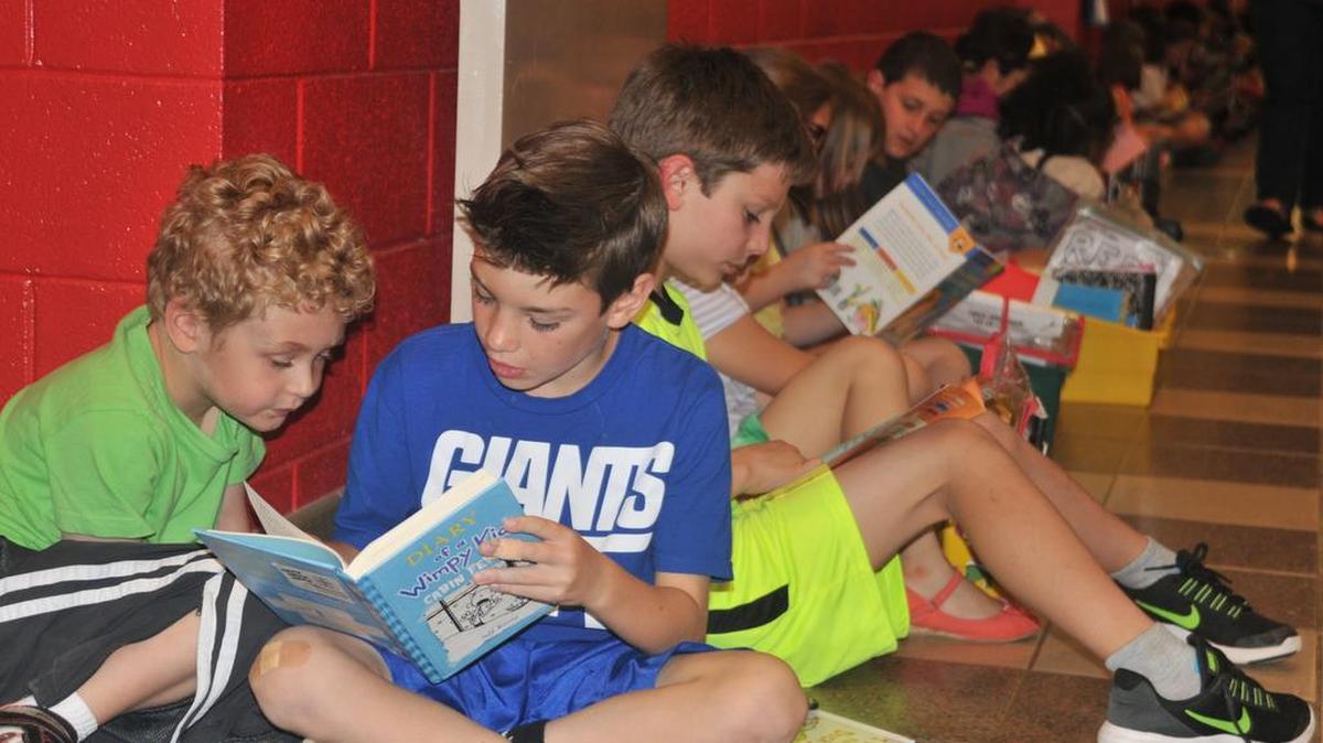 Ethan Monday, Ryder DeWaele and Colin Nelson read in the hallway at Fort Mill Elementary School on Friday afternoon.