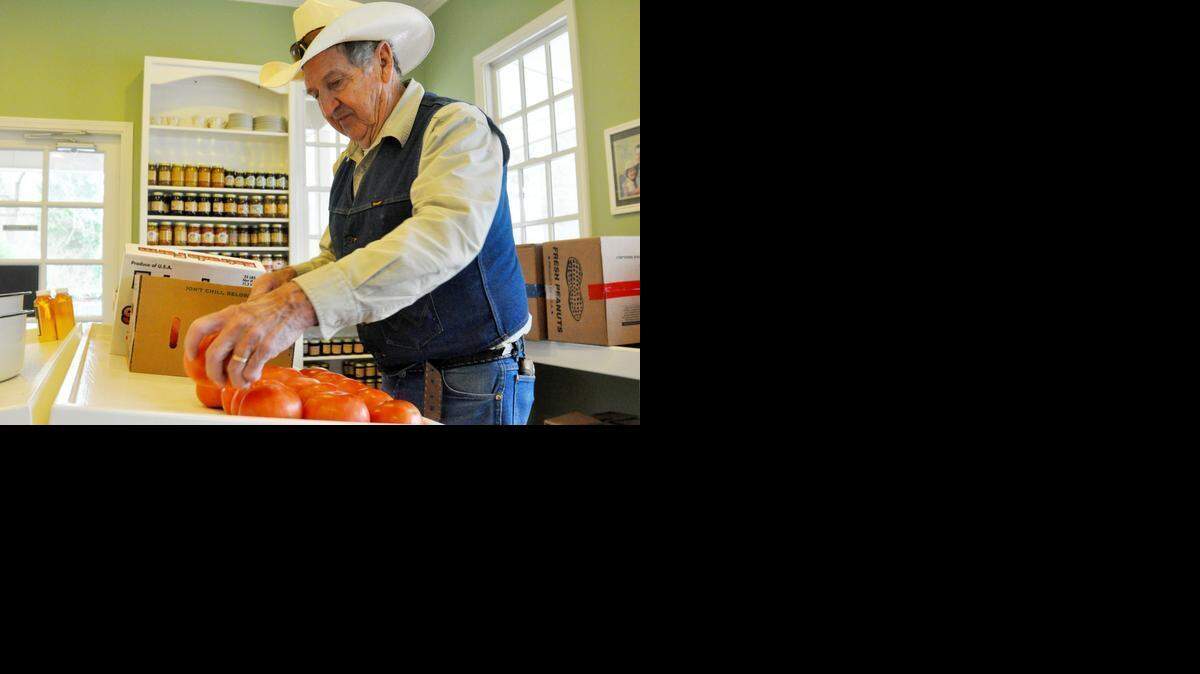 
Tim Reid, owner of South Forty Farms with wife Phyllis in Lake Wylie, sets up tomatoes for opening day April 2 at the roadside produce store on S.C. 274. 
