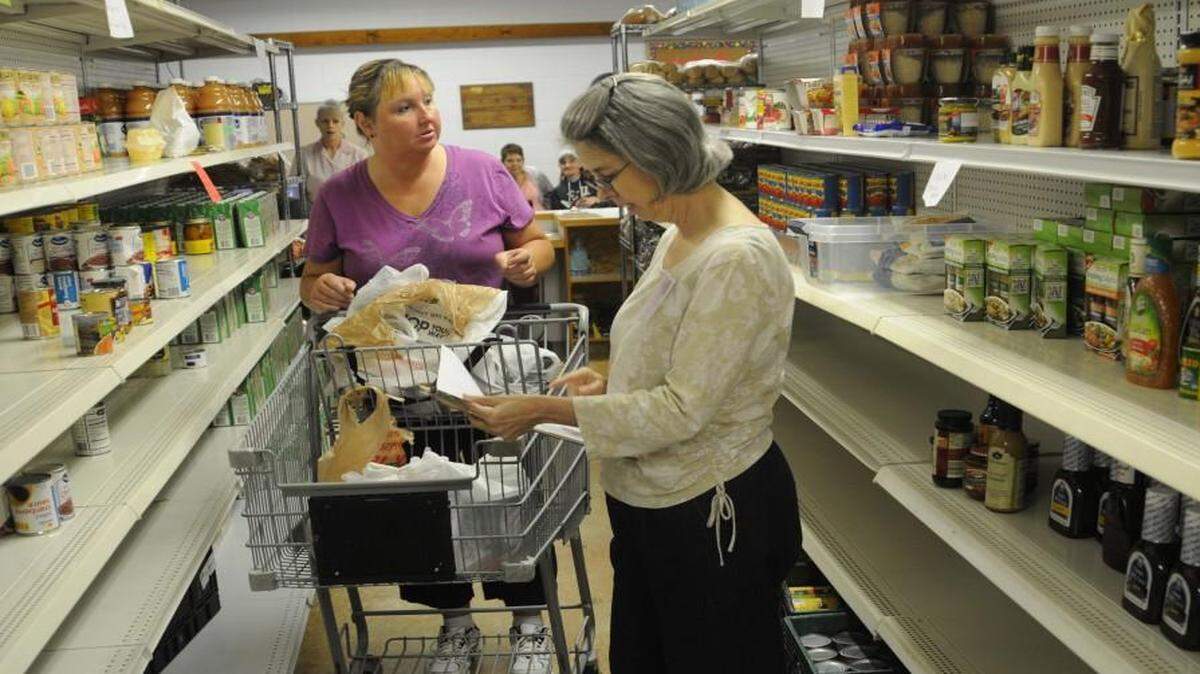 Client Cathy Cook and volunteer Julie Young peruse the new pantry setup at Clover Area Assistance Center. New living basics classes are being piloted in June and July at the Center.