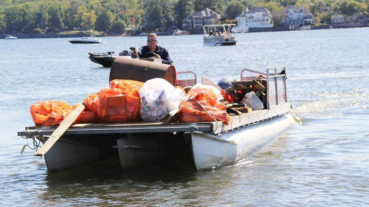 Andy Reynolds pilots a barge of trash he collected from other boats during Riversweep on Lake Wylie.