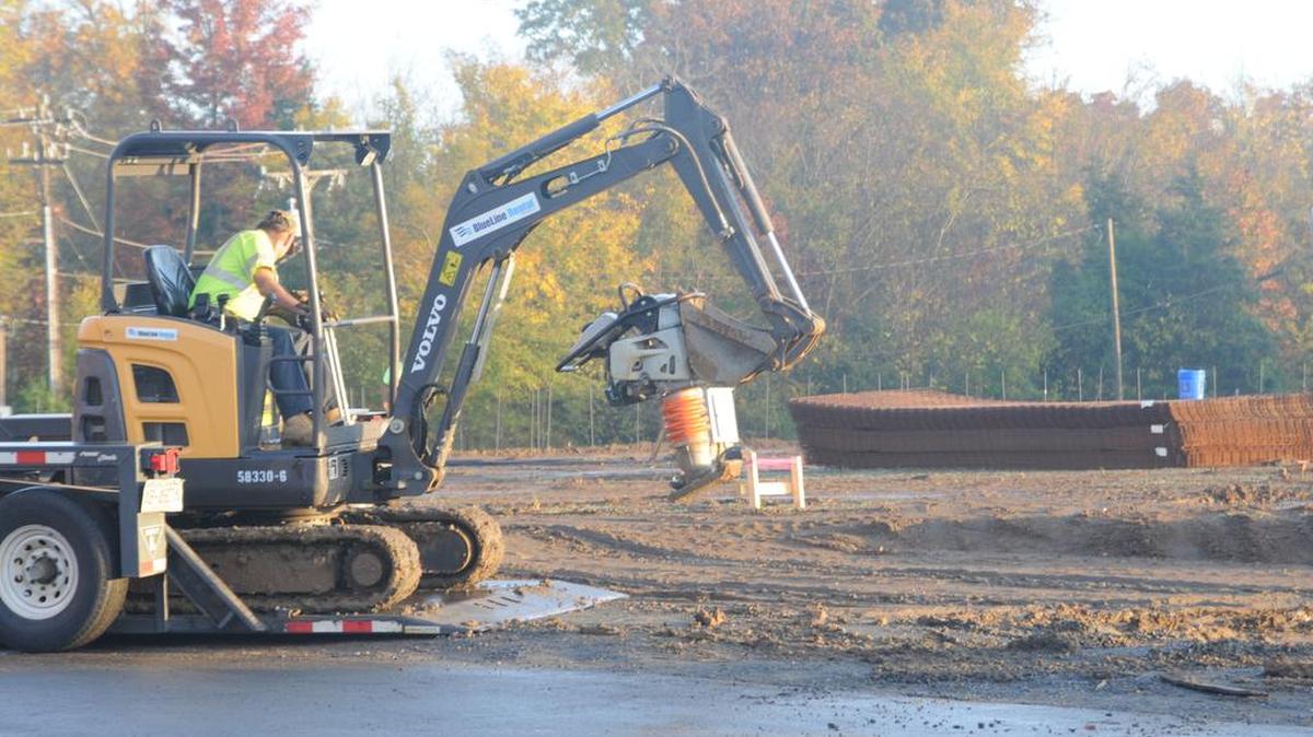 Workers try to manage wet ground on Oct. 29 at the site of a new T.J. Maxx, Five Below and other stores in Steele Creek.