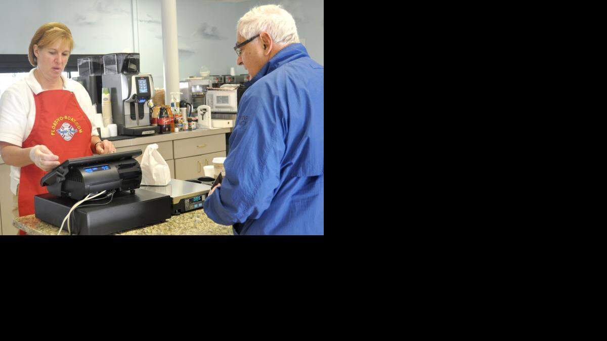 
Mary Ellen Markins rings up customer Hank Degiulio at Bagel Boat in Lake Wylie. The business was a target by a phishing scam.
