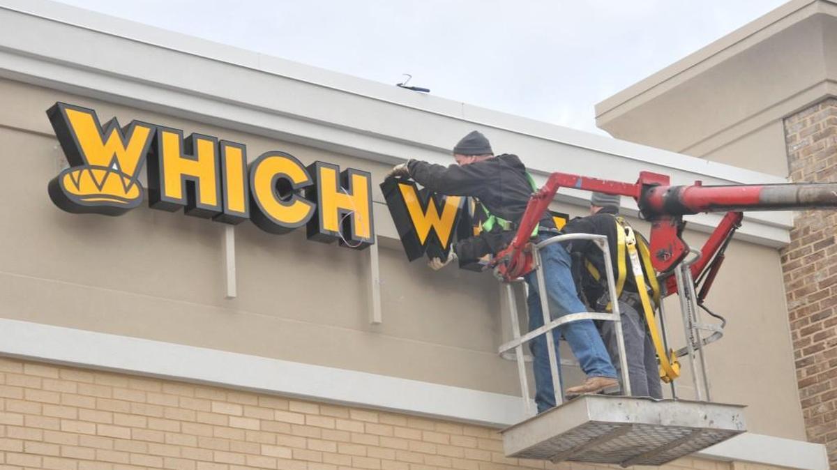 A worker attaches signage to a new building in Indian Land. Lancaster County is considering charging developers impact fees to help offset the cost of growth in the panhandle. The fees could be used for needs such as fire department and police coverage and new roads.