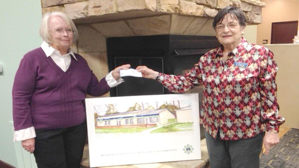 Sue Hapner, left, chairperson for the Tega Cay Women’s Club’s garage sale fundraiser, hands Carol Higgins, director of Fort Mill Care Center, a check for $1,400 to help pay for new facility upgrades. The Care Center provides food, financial assistance and other services to residents in need.