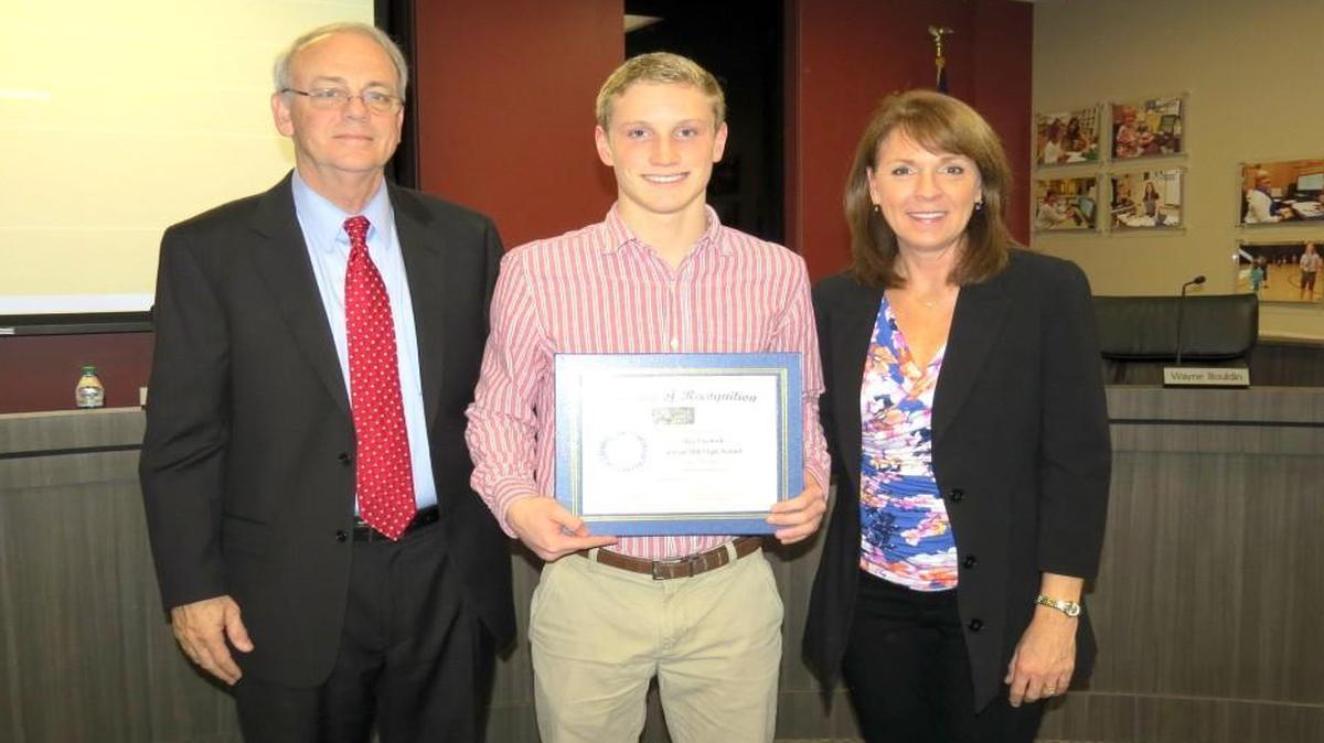 The Fort Mill school Board recognized Fort Mill High School sophomore Ben Fenwick, the South Carolina State Champion in 500 freestyle. "He is a phenomenal swimmer," said swim coach Cindy VanBuskirk, who was also recognized for being named S.C. coach of the Year. "We look forward to watching him continue to excel in this sport," she said. Shown from left are: superintendent Chuck Epps, Ben Fenwick and swim coach Cindy VanBuskirk
