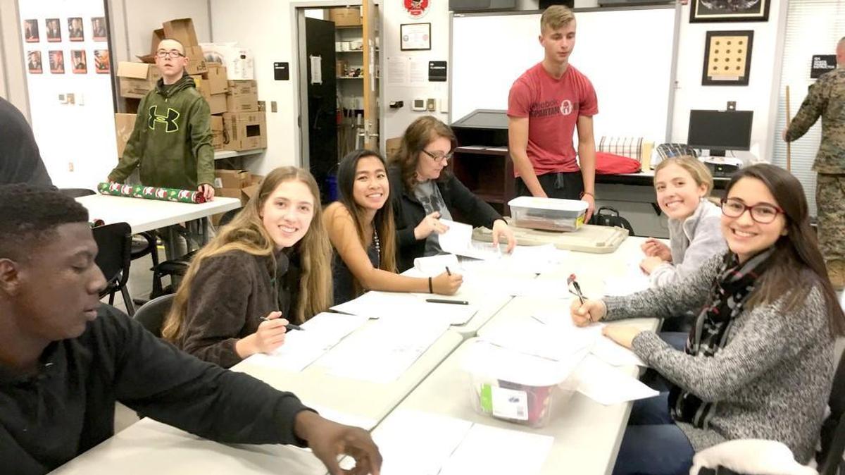 MCJROTC cadets at Nation Ford High School write out holiday cards for U.S. Marines deployed overseas. The students put together gift packages that were sent to the Marines so they would have gifts for the holidays. s