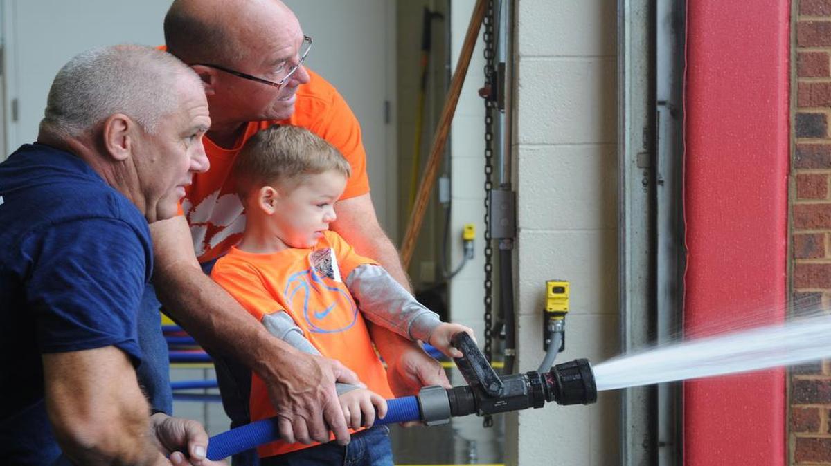 
Will Newell, 3, gets help from his grandpa Kenny and a Fort Mill firefighter as he fires the hose during the FMFD’s 100th birthday celebration last week. The town is building a new station to address continued growth.
