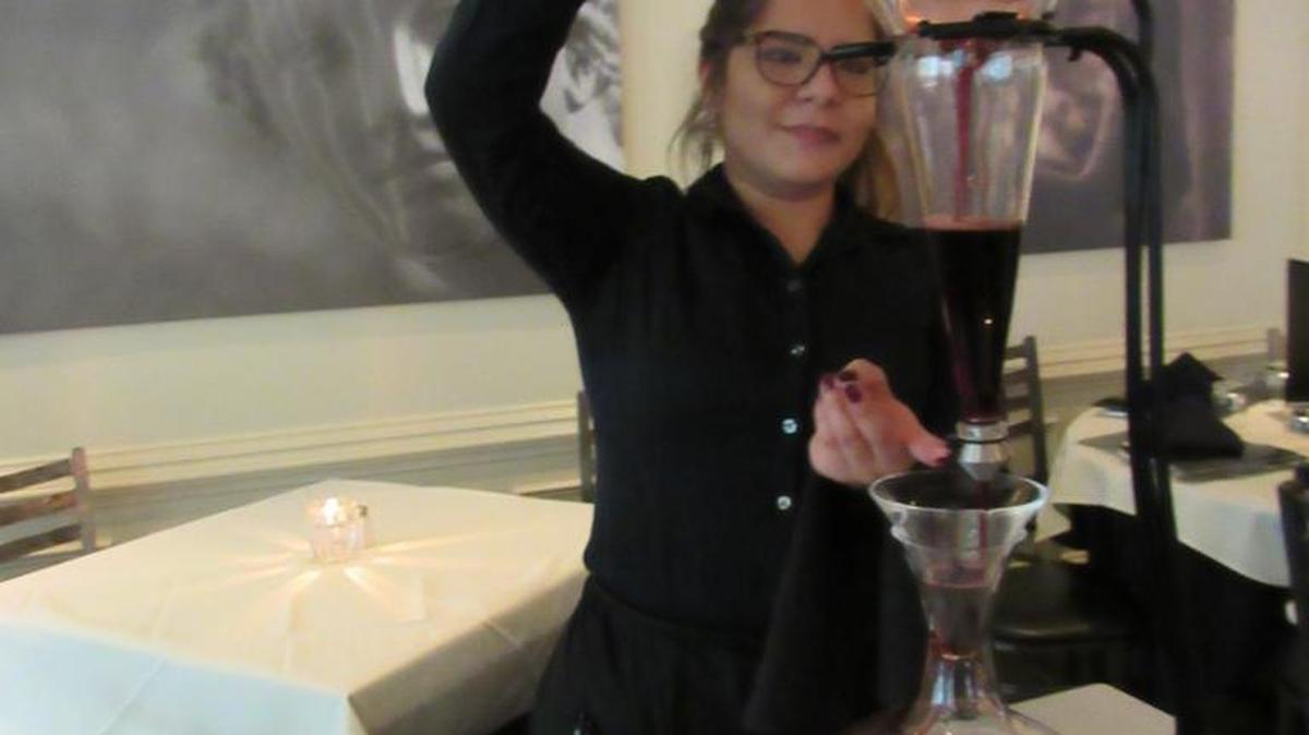 A server uses a decanter from Italy at Luciano’s restaurant in Charlotte.