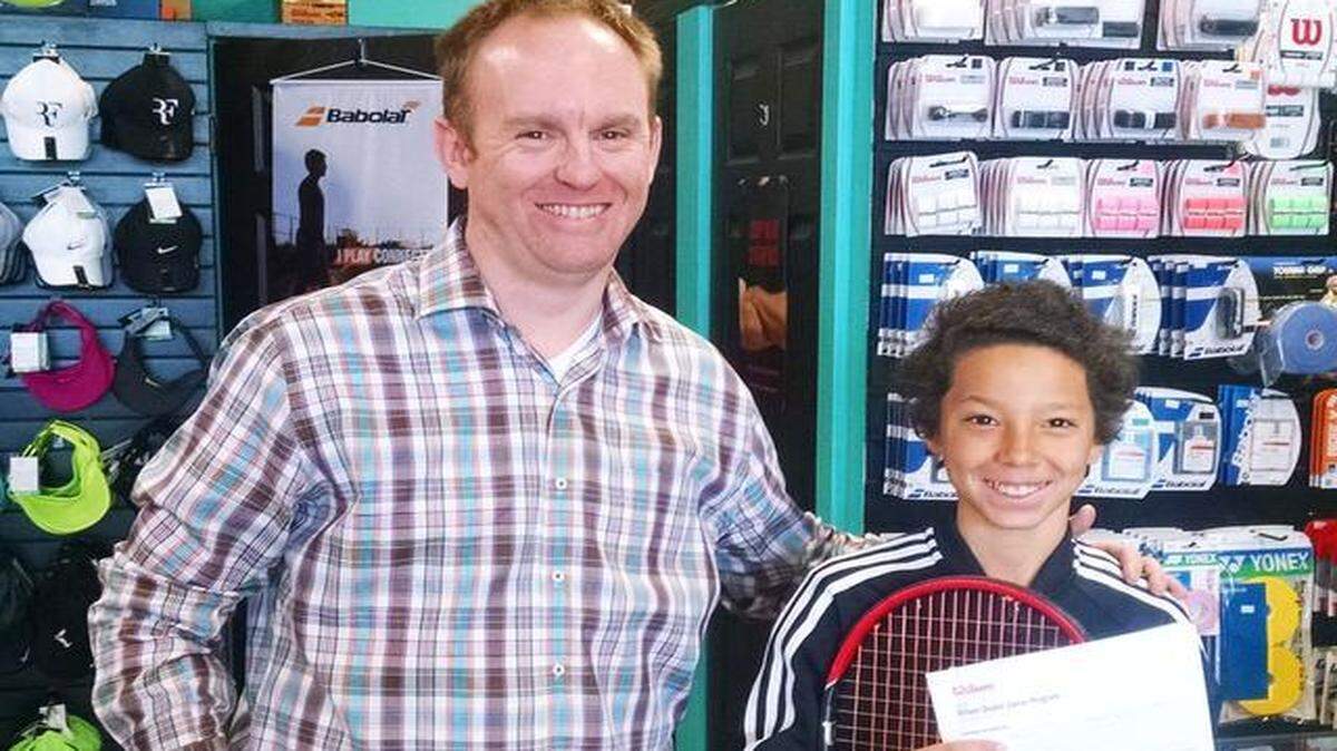 
Mike Lefke, left, owner of Queen City Tennis, stands with River Hills Country Club tennis club member Marco Ward, 12, who accepted a national sponsorship offer from Wilson Sporting Goods Co. 
