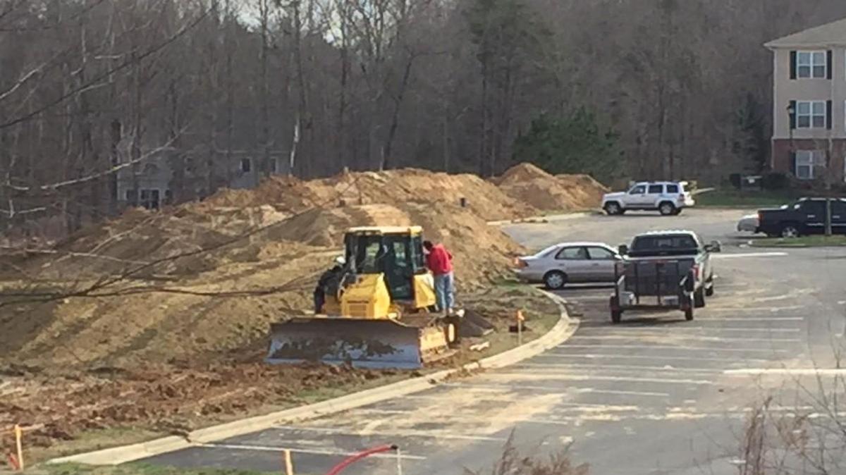 A crew clears land at Millcrest Park, where a new phase of apartments is under construction. 