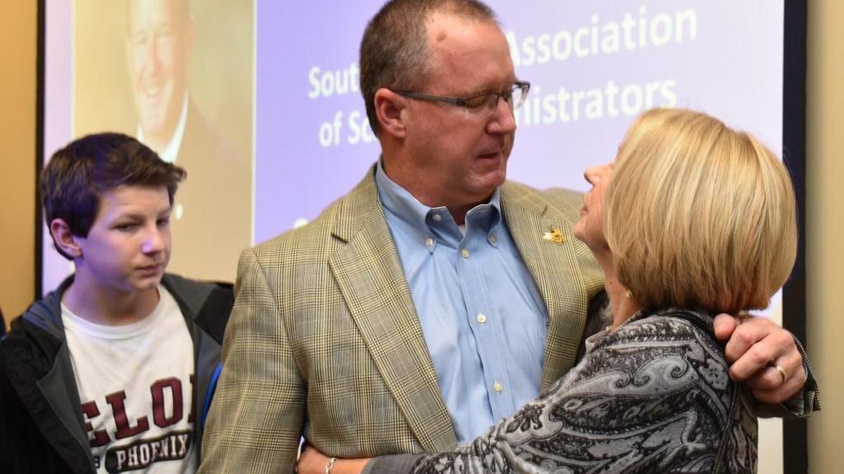 Fort Mill High Principal Dee Christopher is congratulated by his mother Janice Christopher after learning he was selected as Principal of the Year. Behind him is his son, Cabe Christopher.