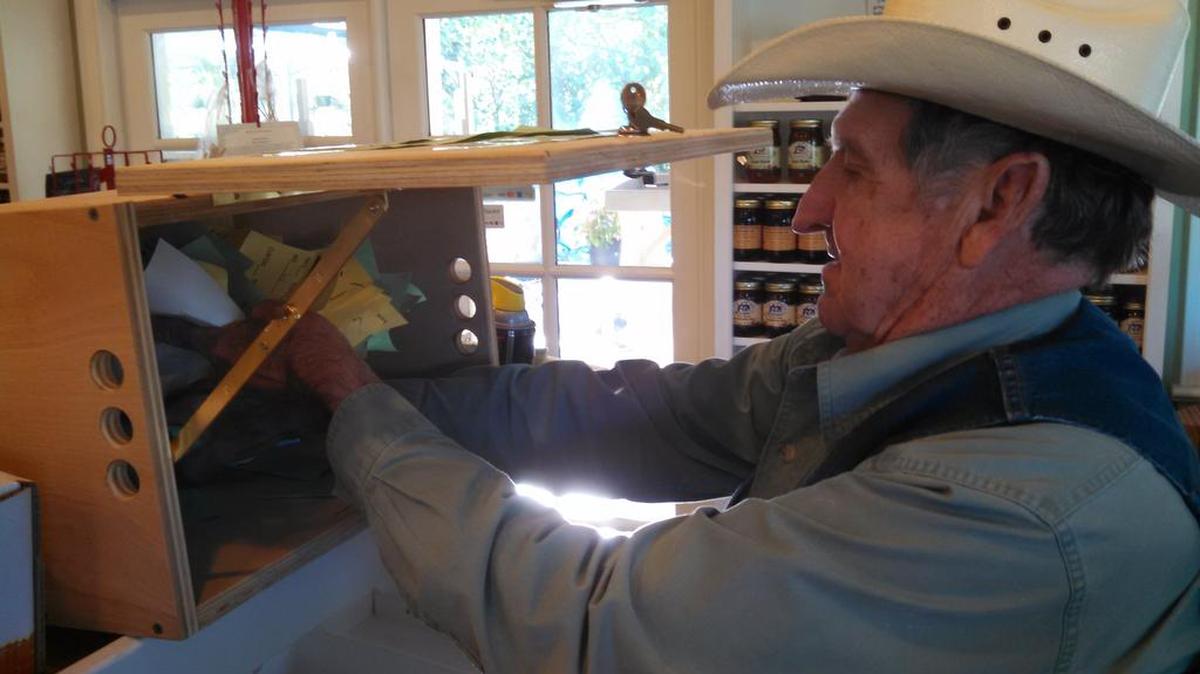 Tim Reid, owner of South Forty Farms in Lake Wylie, takes the last ballots out of the box Friday morning as he tallied votes to see who his customers would pick for president.