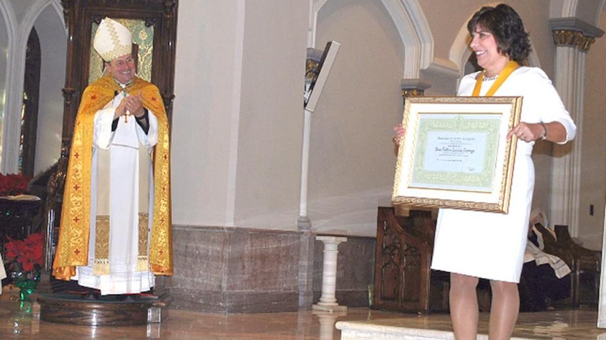 Kathy Schmugge of Fort Mill receives the Benemerenti Medal from the Diocese of Charleston for exemplary service to the Catholic Church. To the left is The Most Rev. Robert E. Guglielmone, Bishop of Charleston. The Benemerenti Medal was one of eight honors handed down to the Diocese from Pope Francis as part of the Church's Year of Mercy.