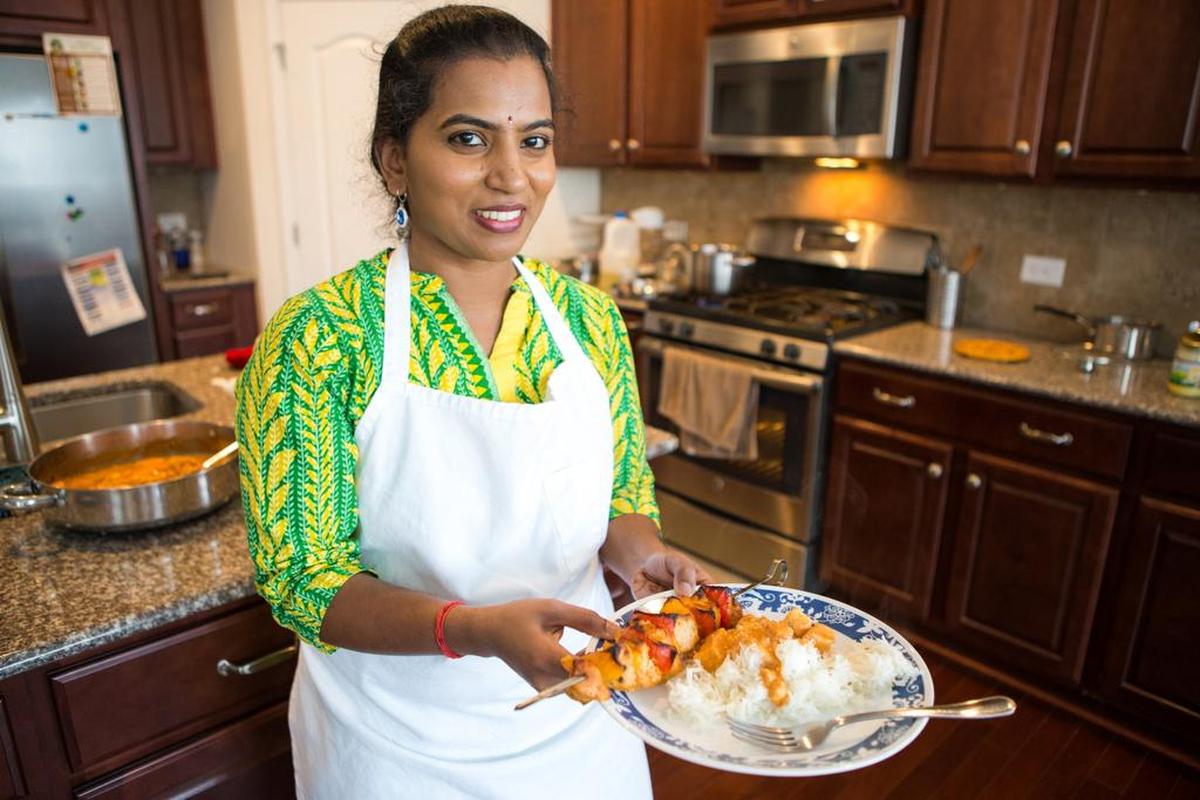 Santhoshi Radhakrishnan shows off a meal of paneer butter masala over jeera rice and chicken tikka. Students created it during one of her cooking classes at her home in Fort Mill in this 2017 file photo. Radhakrishnan has pivoted from teaching Indian cuisine classes in-person to virtually during the COVID-19 pandemic.