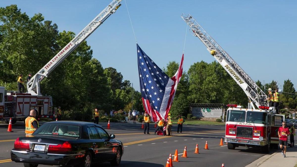 Members of the Tega Cay and Riverview fire departments fly the flag above Tega Cay Drive on Memorial Day in 2015. York County Council decided to fund a new Riverview substation rather than pay for new Tega Cay firefighters to cover a portion of the Riverview district.
