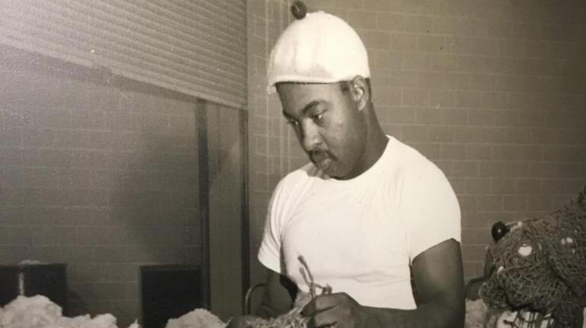 In this photo, taken at the Elliott Plant in 1964, a man performs a roving action, the final phase of carding where fibers are untangled, cleaned and intermixed to produce a continuous string suitable for spinning.