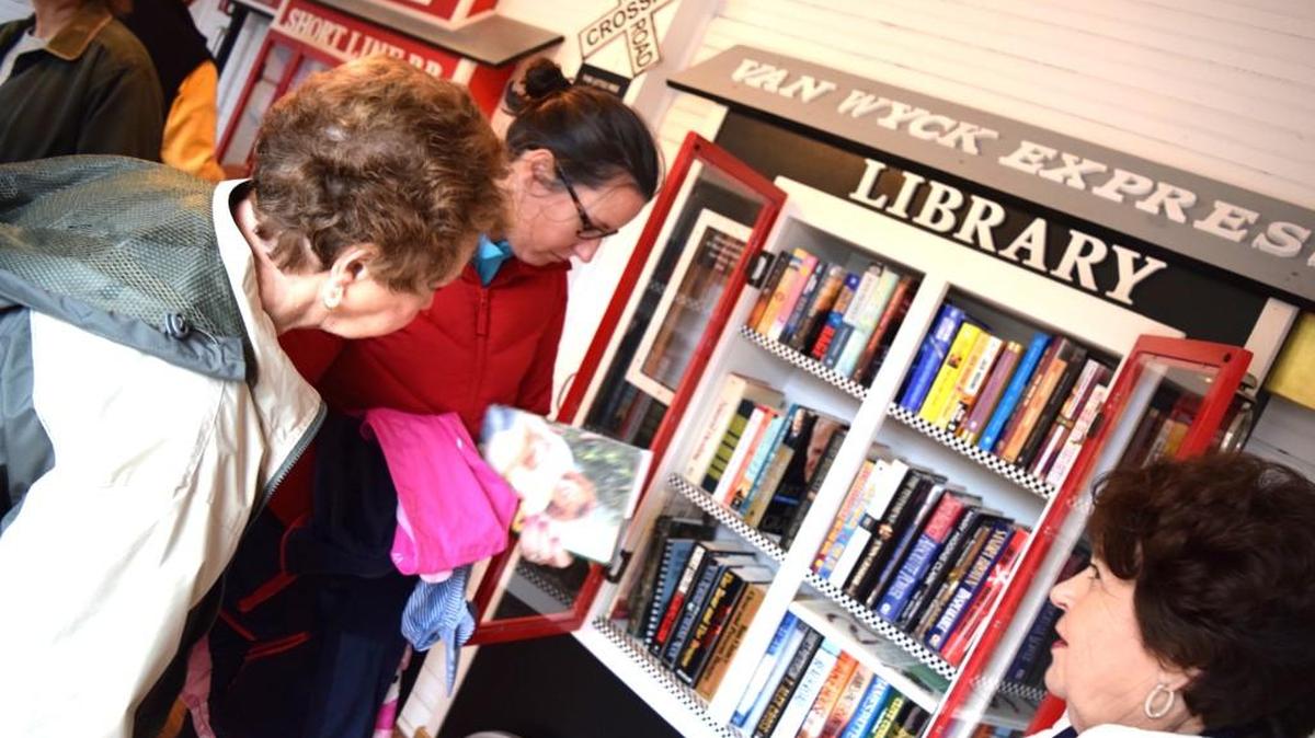 Book seekers check out the titles in the adult section of Van Wyck's Little Free Library.