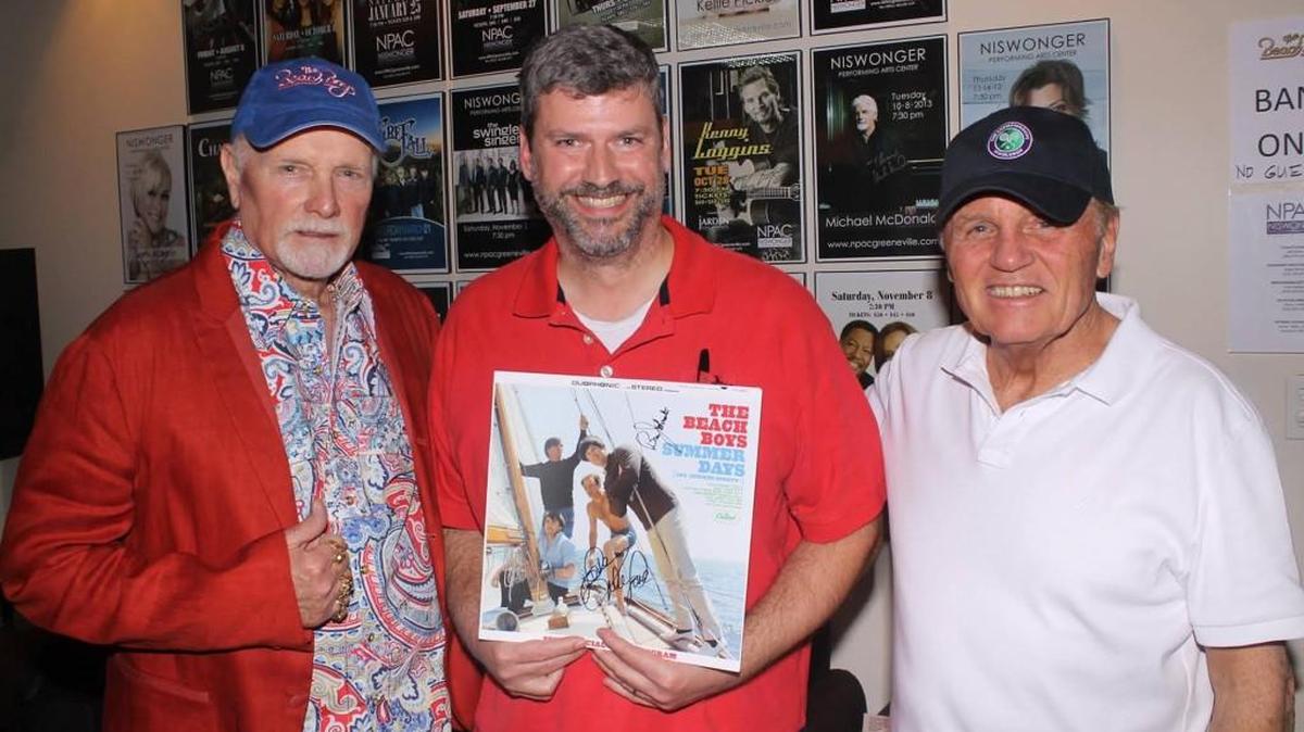 Mike Love (left) and Bruce Johnston (right) of The Beach Boys flank David Beard of Fort Mill, who created the band's award-winning tour progam.