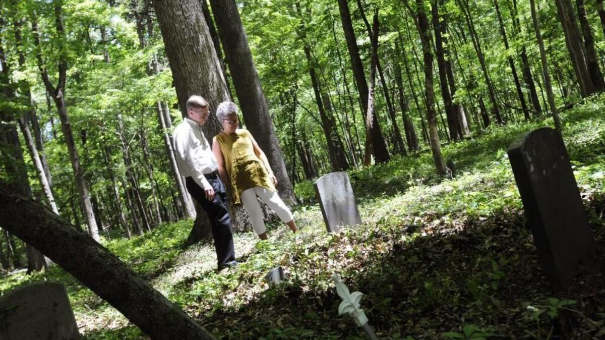 Pastor Sam McGregor, left, and Patrice Gaines look at a former slave's headstone Wednesday at Allison Creek Presbyterian Church, which kicks off the Jazz at Allison Creek series Oct. 28.