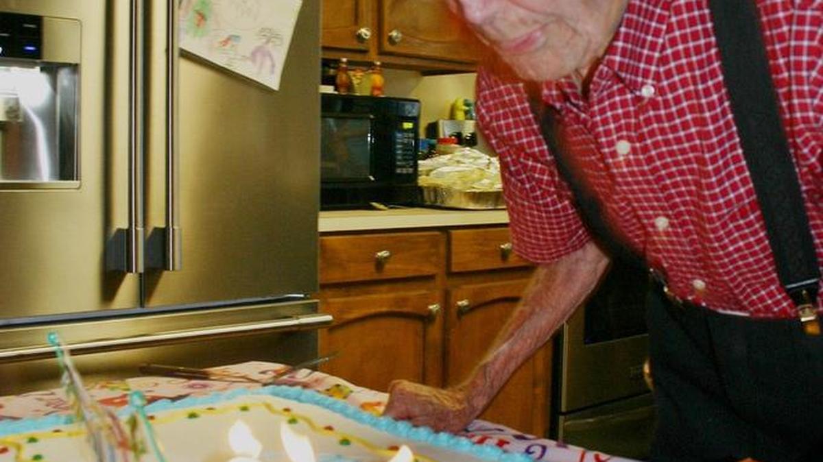 Mack Marker blows out candles for his 100th birthday party.